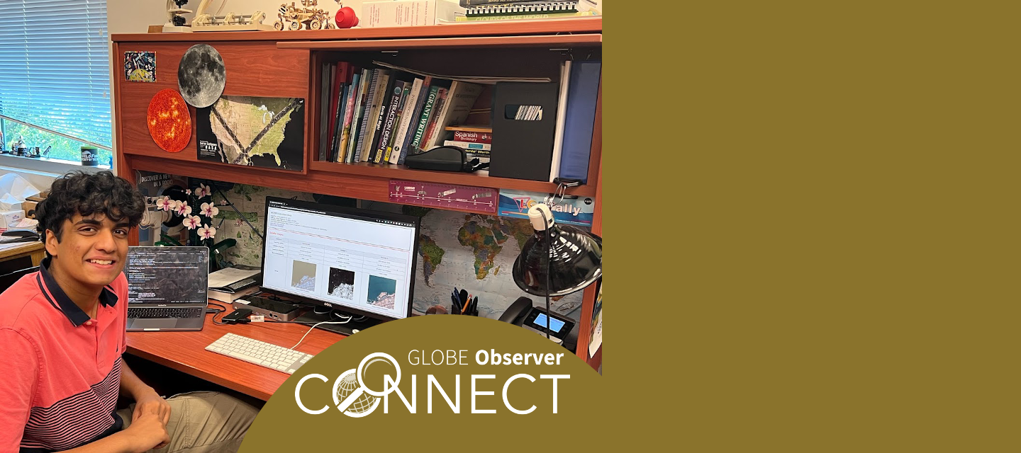 An intern sits at a desk in front of computer screens with code and satellite images on them.